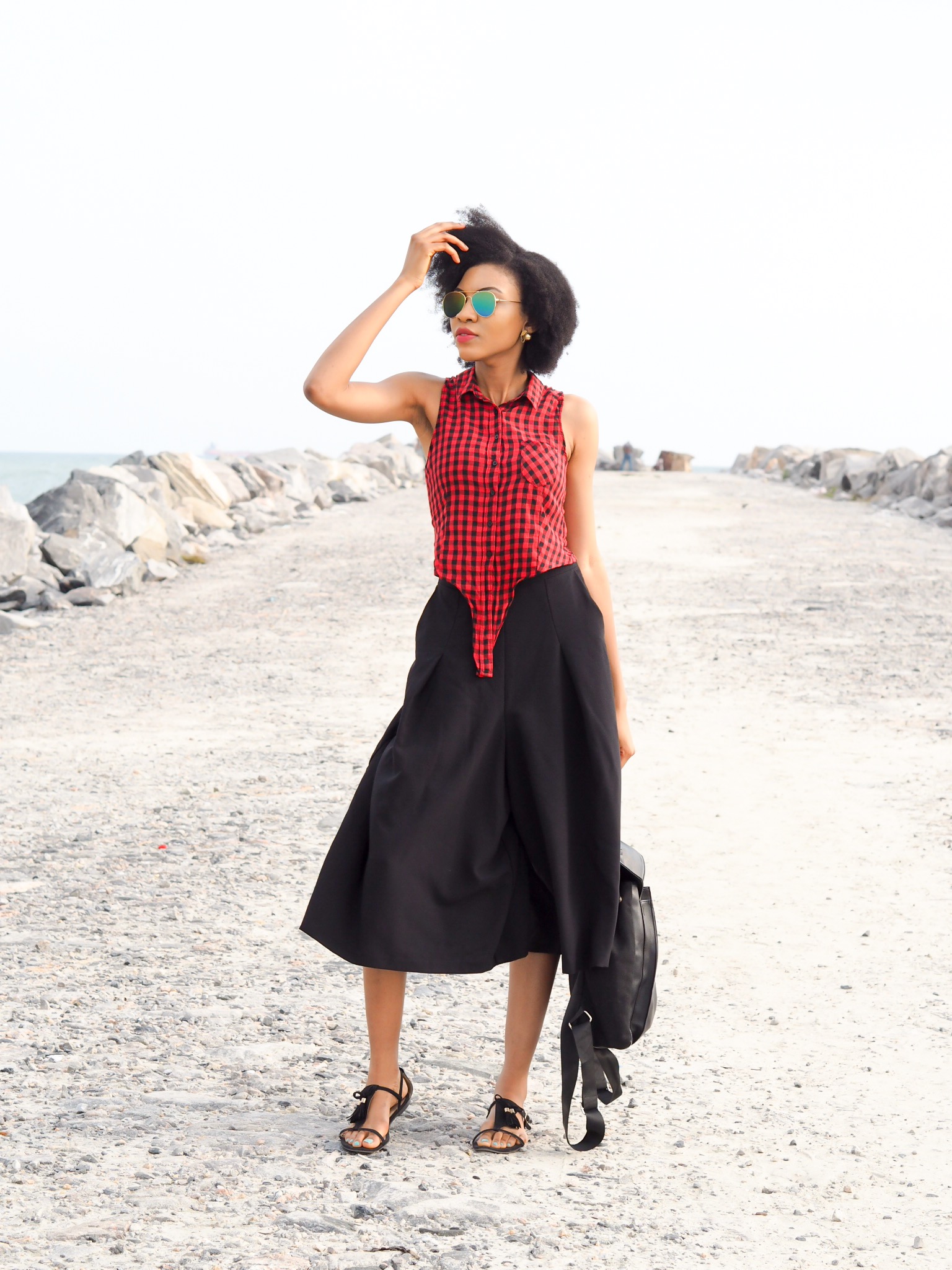 Nigerian blogger Modavracha in red check shirt outfit at the beach
